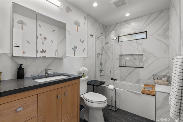 bathroom featuring visible vents, toilet, backsplash, tile walls, and vanity