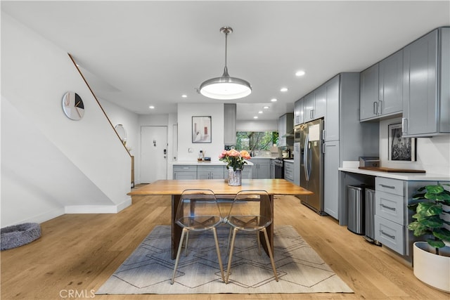 dining area with stairway, recessed lighting, light wood-style floors, and baseboards