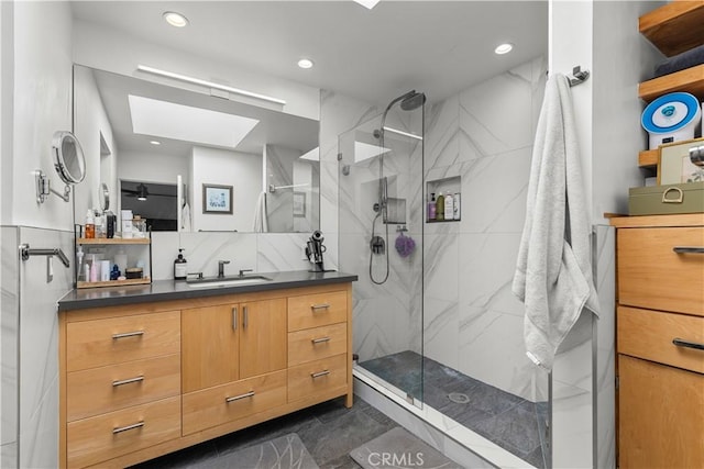 bathroom with vanity, a skylight, recessed lighting, and a marble finish shower