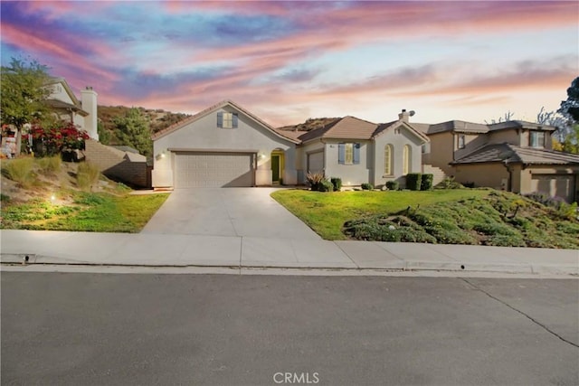 view of front of house featuring stucco siding, a front lawn, concrete driveway, an attached garage, and a chimney