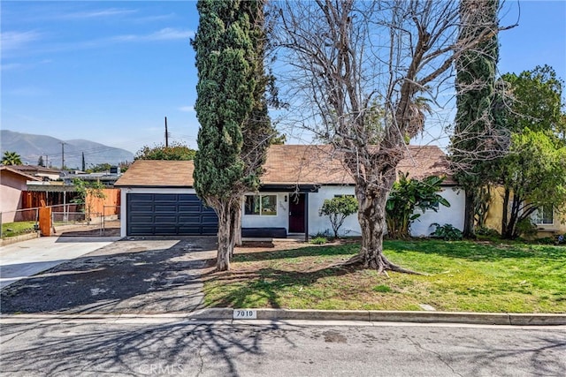 view of front facade featuring fence, stucco siding, a front lawn, concrete driveway, and a garage