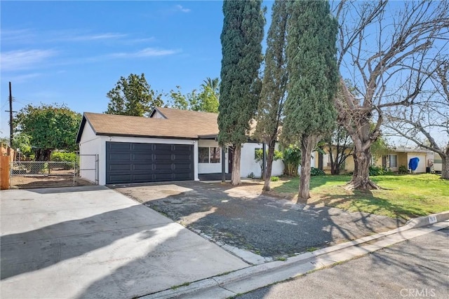 view of front facade with an attached garage, driveway, a front lawn, and fence