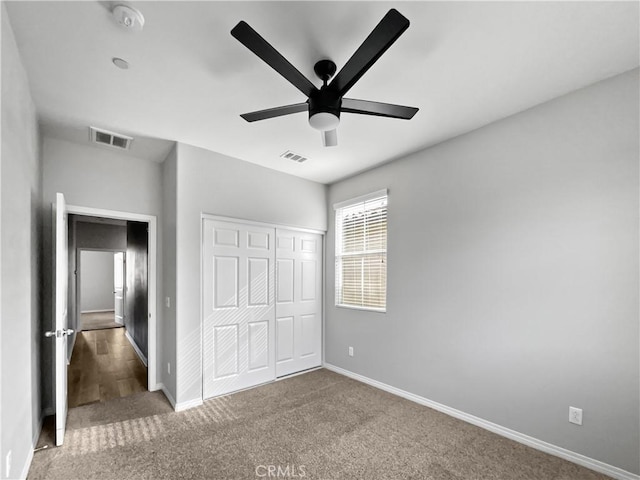 unfurnished bedroom featuring baseboards, visible vents, a closet, and carpet floors