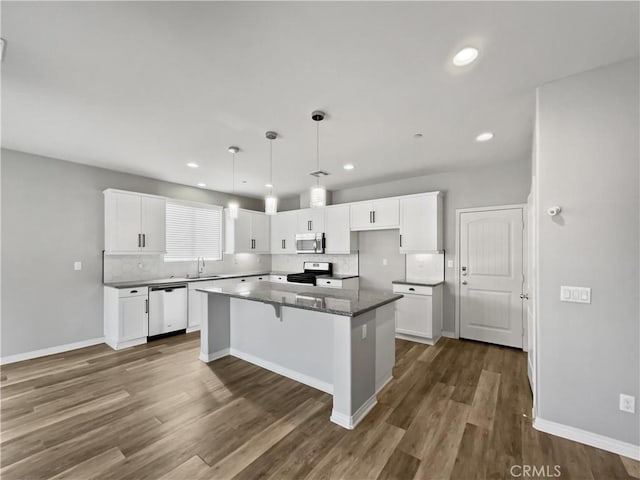 kitchen featuring a center island, dark wood-style floors, backsplash, and stainless steel appliances