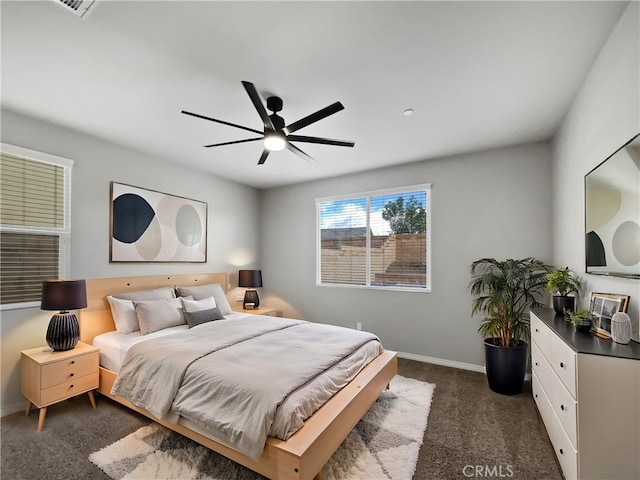 bedroom with a ceiling fan, baseboards, and dark colored carpet