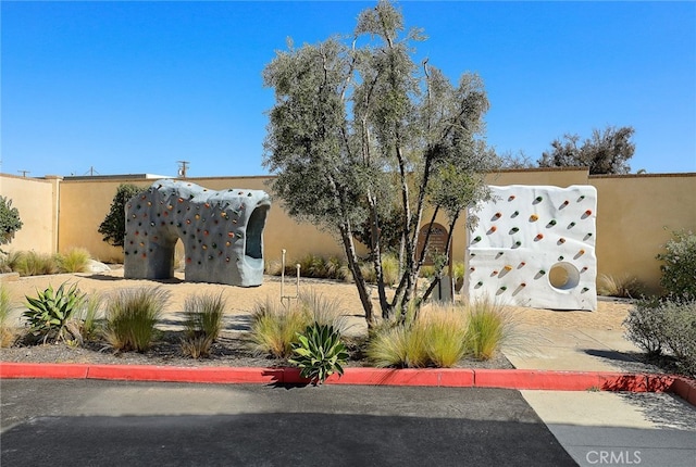 view of front facade featuring stucco siding and fence