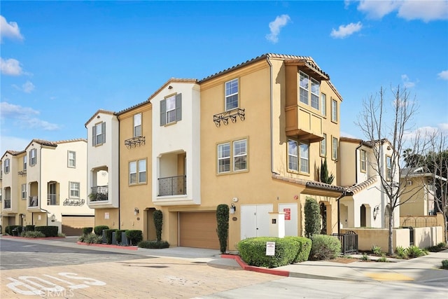 view of property with a garage, a residential view, and driveway