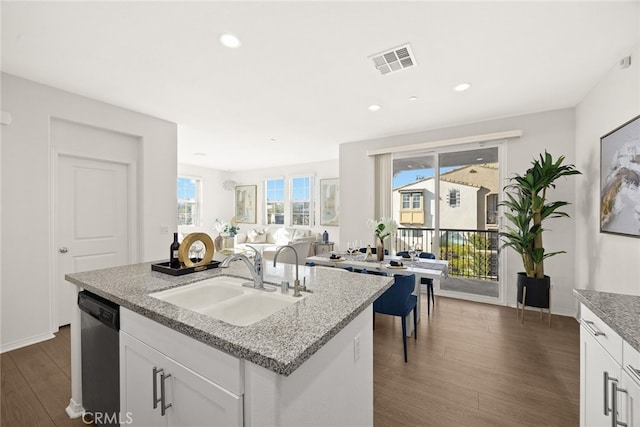 kitchen featuring visible vents, dark wood finished floors, dishwasher, white cabinetry, and a sink