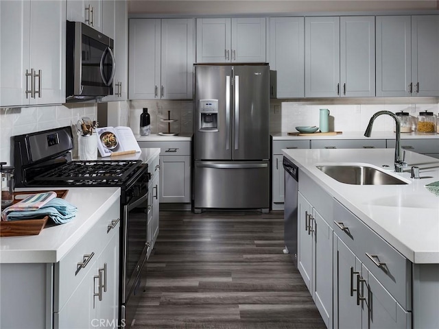 kitchen featuring a sink, light countertops, gray cabinets, and stainless steel appliances