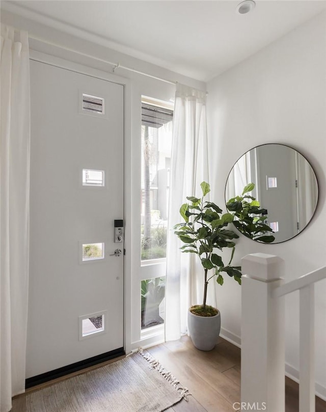 foyer featuring baseboards and wood finished floors