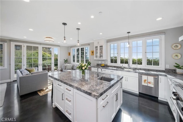 kitchen featuring white cabinetry, open floor plan, appliances with stainless steel finishes, and a sink