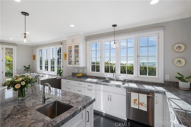 kitchen with decorative light fixtures, white cabinets, dishwasher, and a sink