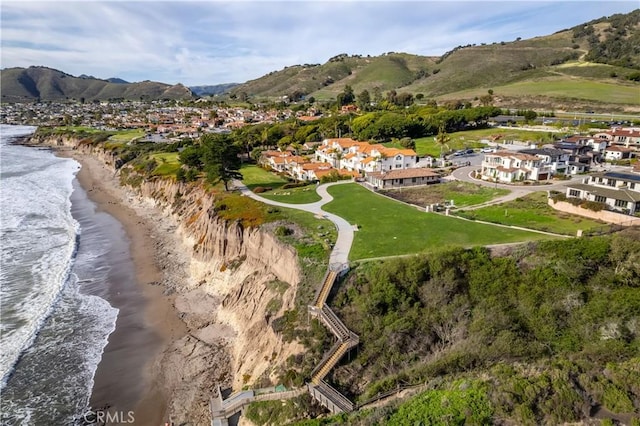 drone / aerial view featuring a view of the beach and a water and mountain view