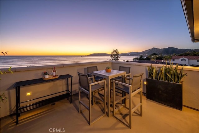 view of patio with a water view and outdoor dining space