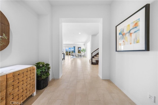 corridor featuring light tile patterned floors, stairway, baseboards, and recessed lighting