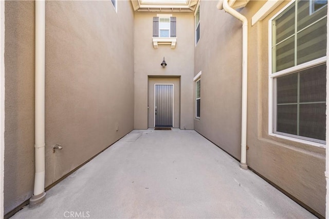 entrance to property with stucco siding and a patio area