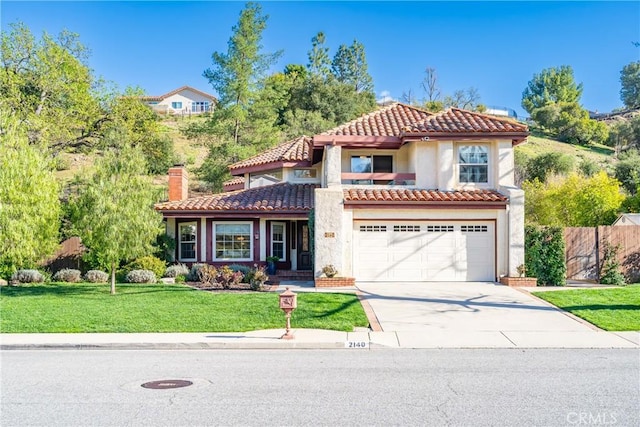 mediterranean / spanish-style home featuring a chimney, stucco siding, a front lawn, concrete driveway, and a tile roof