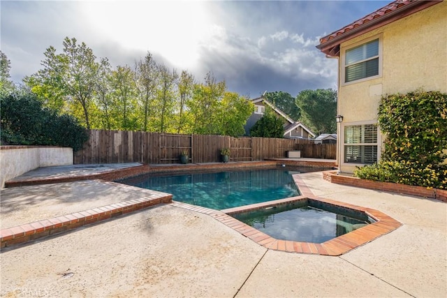 view of pool featuring an in ground hot tub, a patio area, a fenced in pool, and a fenced backyard