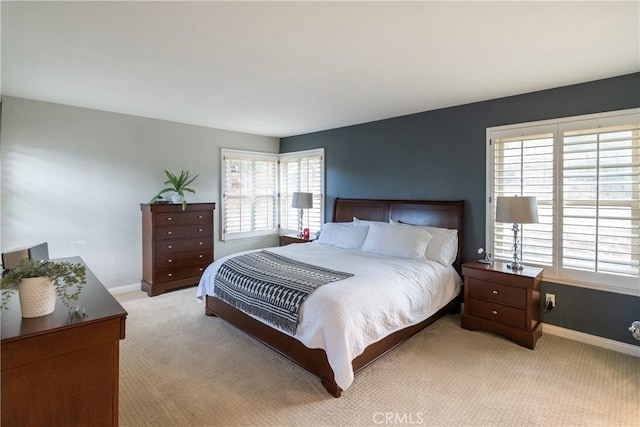 bedroom with light carpet and baseboards