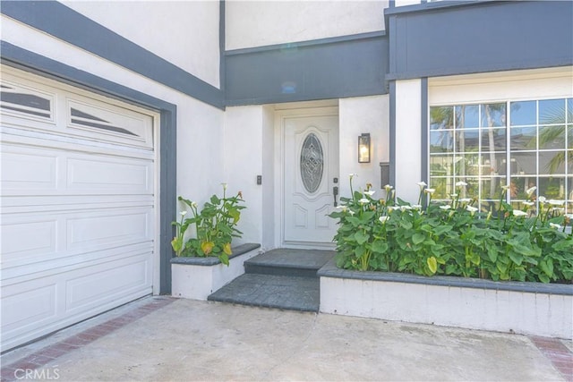 doorway to property with stucco siding and an attached garage