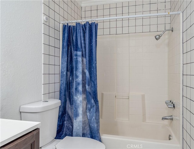 bathroom with vanity, toilet, a textured wall, and shower / bath combo