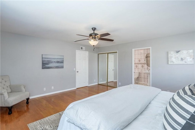 bedroom featuring ceiling fan, visible vents, baseboards, and wood finished floors