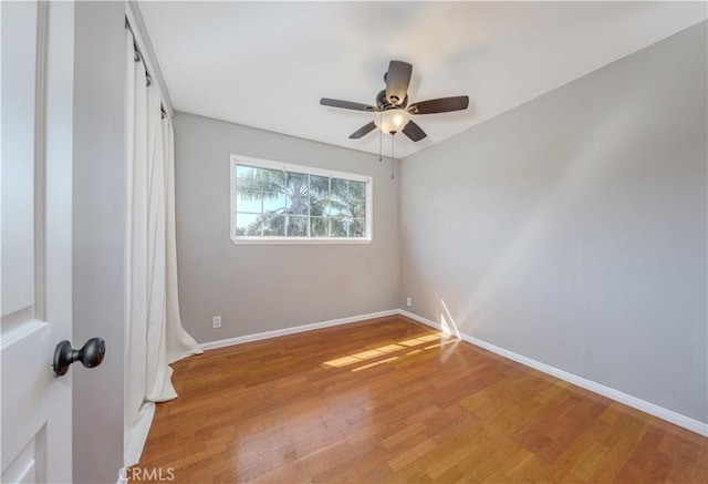 empty room with ceiling fan, baseboards, and light wood-style floors