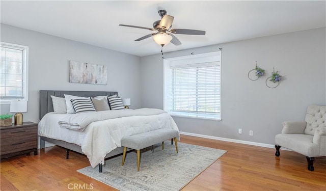 bedroom featuring ceiling fan, baseboards, and wood finished floors