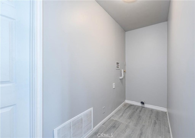 laundry room featuring laundry area, light wood-style floors, visible vents, and baseboards