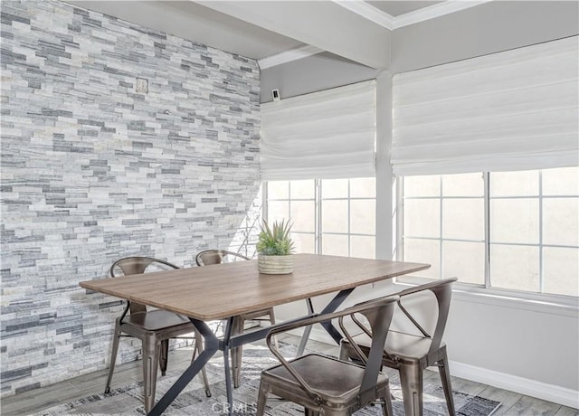 dining space with baseboards, wood finished floors, and crown molding