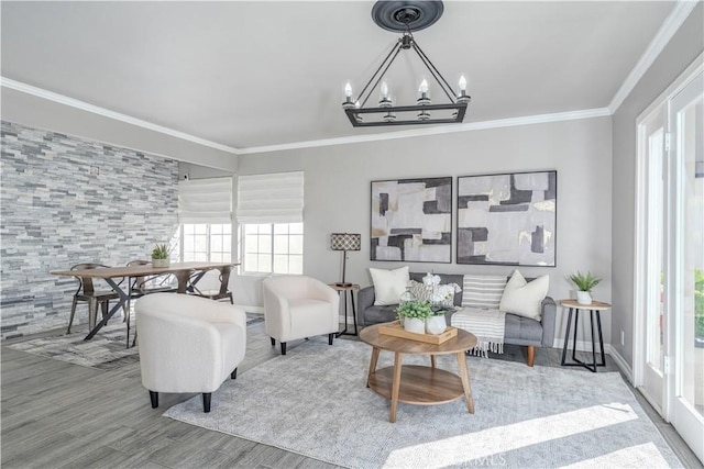 living area with a chandelier, wood finished floors, and ornamental molding