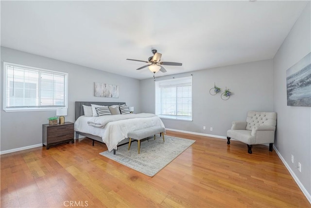 bedroom with light wood-type flooring, baseboards, and ceiling fan