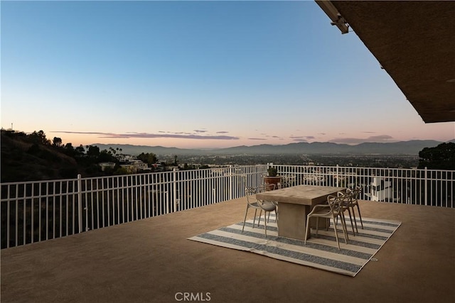 view of patio / terrace featuring a mountain view, outdoor dining area, and fence