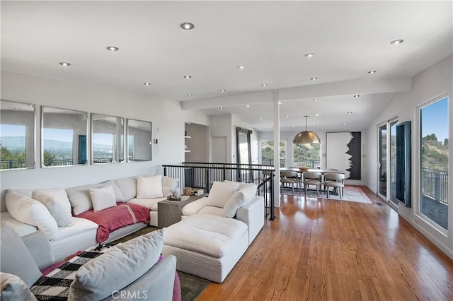 living room featuring recessed lighting, light wood-style flooring, and lofted ceiling