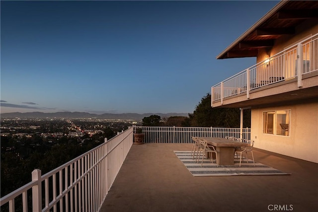 view of patio / terrace featuring a mountain view, a balcony, and outdoor dining space