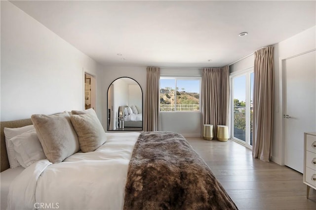 bedroom with light wood-type flooring and access to exterior