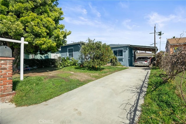 obstructed view of property featuring stucco siding, an attached carport, and concrete driveway