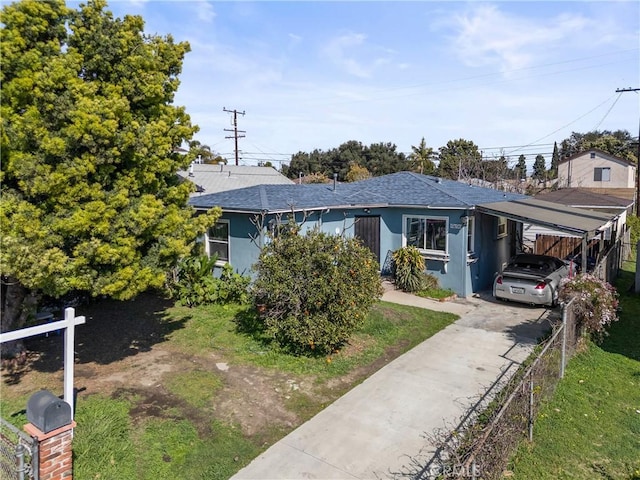 view of front of home featuring a carport, fence, driveway, and stucco siding