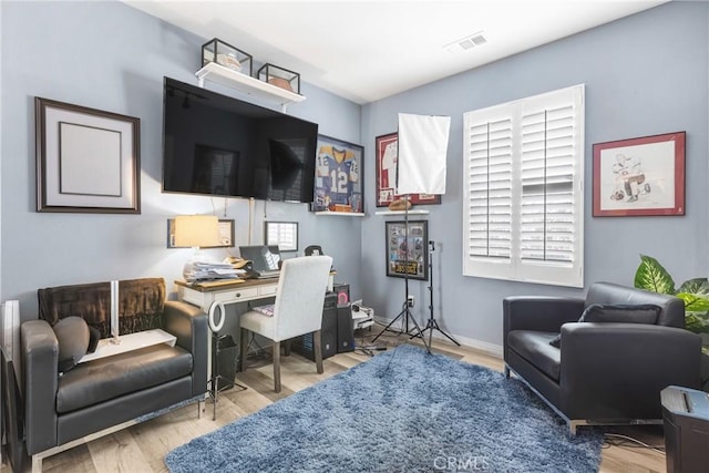 office area featuring visible vents, baseboards, and wood finished floors