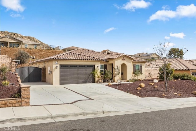 view of front facade with concrete driveway, a gate, a garage, and stucco siding