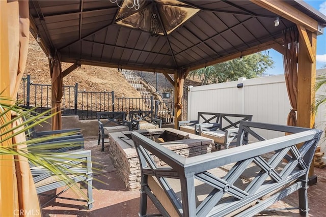 view of patio with a gazebo, fence, and an outdoor fire pit