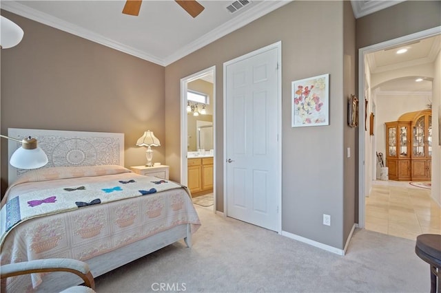 bedroom with visible vents, baseboards, ensuite bath, crown molding, and light colored carpet