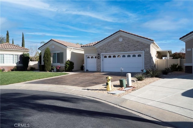 view of front facade featuring a tile roof, a front yard, a garage, stone siding, and driveway