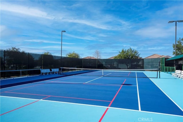 view of tennis court featuring fence