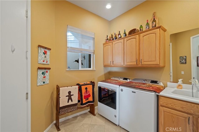 laundry area featuring baseboards, washer and clothes dryer, light tile patterned floors, cabinet space, and a sink