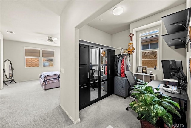 carpeted office space featuring visible vents, baseboards, and a ceiling fan