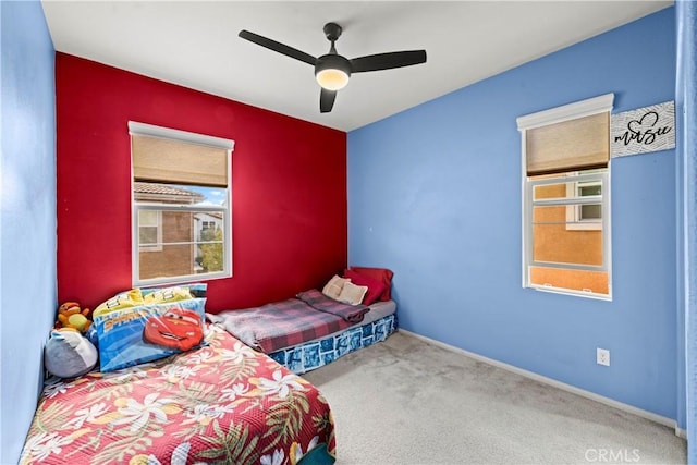 bedroom featuring baseboards, carpet floors, and a ceiling fan