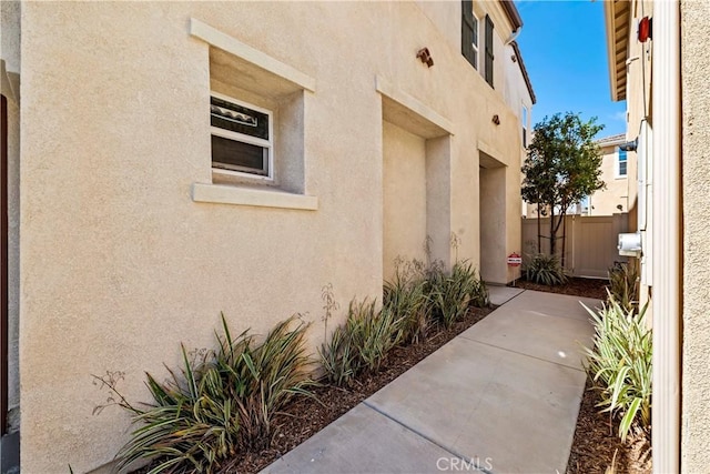 exterior space featuring stucco siding and fence