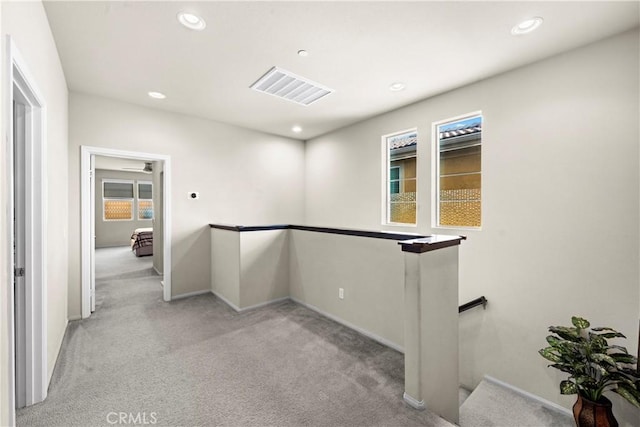 corridor with visible vents, baseboards, carpet, an upstairs landing, and recessed lighting