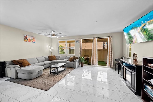 living area with marble finish floor and a ceiling fan